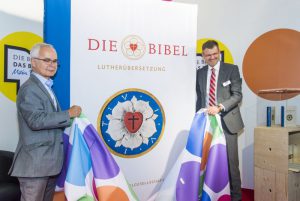 Heinrisch Riethmüller und Christoph Rösel enthüllen die große Lutherbibel. Foto: DBG